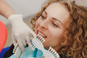 Clínica Dental Naves. Mujer probando tonos de carillas dentales